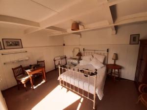 a bedroom with a bed and a table and a desk at On the River, Right by the Sea in East London
