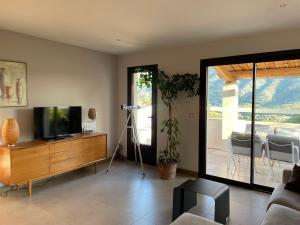 a living room with a television on a wooden dresser at Les Terrasses du Ventoux in Mollans-sur-Ouvèze