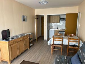 a living room with a kitchen and a table with chairs at Appartement Saint-Gilles-Croix-de-Vie, 2 pièces, 4 personnes - FR-1-224-39 in Saint-Gilles-Croix-de-Vie