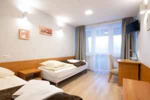 a hotel room with two beds and a window at Zajazd Kałużna in Łącko