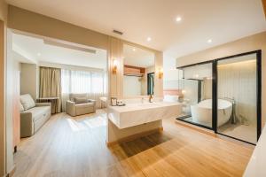 a bathroom with a large tub and a large mirror at THEE Bangkok by TH District in Bangkok