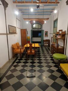 a room with tables and chairs on a checkered floor at Hostel Vasantashram CST Mumbai in Mumbai