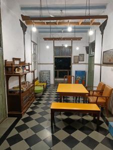 a room with tables and chairs and a checkered floor at Hostel Vasantashram CST Mumbai in Mumbai
