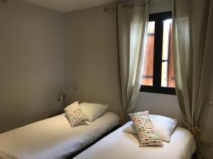 two beds in a room with a window at Les Terrasses du Ventoux in Mollans-sur-Ouvèze