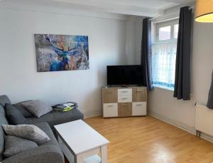 a living room with a couch and a flat screen tv at Innenstadt Perle in Celle