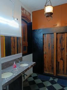 a bathroom with two sinks and a mirror at Hostel Vasantashram CST Mumbai in Mumbai