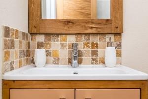 a bathroom sink with two vases on top of it at Cornwall cottage The Old Piggery in Liskeard