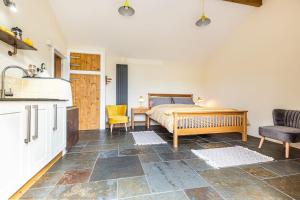 a kitchen and a bedroom with a bed and a table at Cornwall cottage The Old Piggery in Liskeard +6 photos
