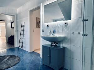 a bathroom with a sink and a mirror at FeWo Lindenallee II Modernes DG-Apartment in Nordhorn
