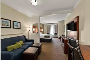 a hotel room with a couch and a bed at Comfort Suites Central in Corpus Christi