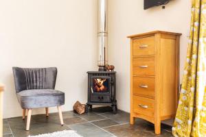 a room with a chair and a wood stove at Cornwall cottage The Old Piggery in Liskeard