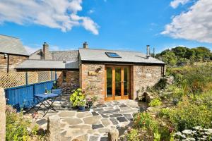 a stone house with a table and a patio at Cornwall cottage The Old Piggery in Liskeard