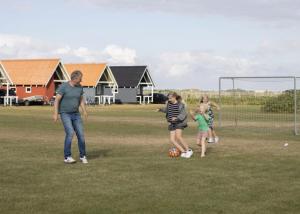 Un gruppo di persone che giocano a calcio su un campo di Camping Vesterhav a Harboør