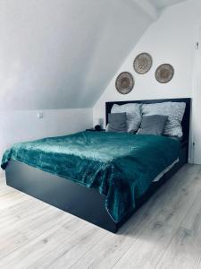 a bedroom with a large bed with a green comforter at FeWo Lindenallee II Modernes DG-Apartment in Nordhorn