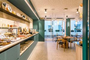 a restaurant with a counter with a table and chairs at Vincci Bonjardim in Porto