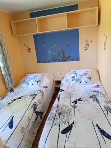 two beds in a room with a painting on the wall at Villa Ardilla (La Adrada) in La Adrada