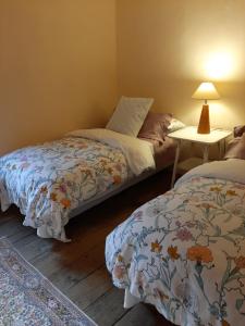 1 dormitorio con 2 camas y mesa con lámpara en The Manor House, en Barreda