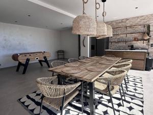 uma sala de jantar com uma mesa de madeira e cadeiras em Villa Les Issambres, 9 pièces, 14 personnes - FR-1-768-50 em Les Issambres