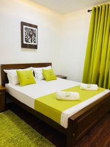 a bedroom with a bed with two yellow pillows at Apartment lake kurunegala in Kurunegala