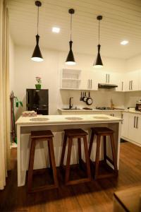 a kitchen with a large white counter with two stools at Apartment lake kurunegala in Kurunegala