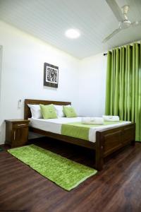 a bedroom with a bed with a green curtain at Apartment lake kurunegala in Kurunegala