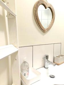 La salle de bains est pourvue d'un miroir au-dessus d'un lavabo. dans l'établissement Charming Terrace Home in Whitchurch, à Whitchurch