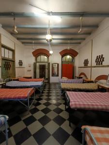 ムンバイにあるHostel Vasantashram CST Mumbaiのベッド数台が備わる客室で、チェックフロアが付いています。