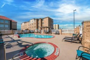 eine Terrasse mit einem Pool und einem Gebäude in der Unterkunft Comfort Suites Central in Corpus Christi