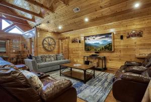 a living room with leather furniture in a cabin at Prestigious, Luxury, Pool, Game Room, Mtn Views in Sevierville