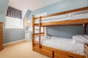 a bedroom with two bunk beds and a window at The Stables Loft, Close to Elie Beach in Elie