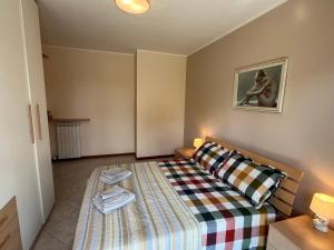 een kleine slaapkamer met een bed met een gestreepte deken bij DISCOVERY FLAT with pool & bikes in Sirmione +45 foto's