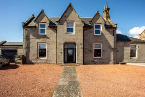an old house with a gravel driveway in front of it at South Beach View in Troon