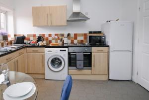 cocina con nevera y lavadora en Inviting 2-Bed apartment - Perfect for Contractors and Business Travellers en Retford