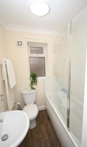 a bathroom with a toilet and a tub and a sink at Inviting 2-Bed apartment - Perfect for Contractors and Business Travellers in Retford