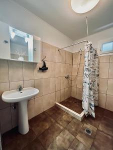 baño con lavabo y cortina de ducha en Felix Vila, en Nea Plagia