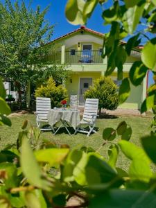 two chairs and a table in front of a house at Felix Villa in Nea Plagia