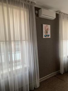 um quarto com cortinas brancas e uma janela em Yurus Hostel em Lviv