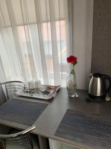 Yurus Hostel في إلفيف: طاولة مع إناء من الزهور ونافذة