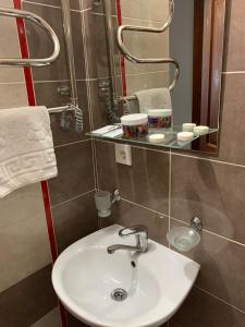 W łazience znajduje się umywalka i lustro. w obiekcie Yurus Hostel w Lwowie