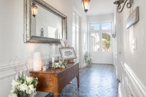 a hallway with a mirror and a table with flowers at La maison de Joséphine - Demeure familiale - 4* in Île dʼAix