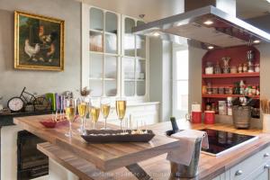a kitchen with a counter with glasses of wine at La maison de Joséphine - Demeure familiale - 4* in Île dʼAix