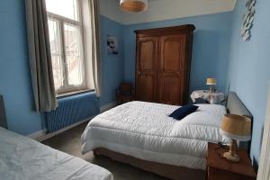 - une chambre bleue avec 2 lits et une fenêtre dans l'établissement Appartement 5 pers, à 200 m de la plage de Wimereux - Chalet Valentine, à Wimereux