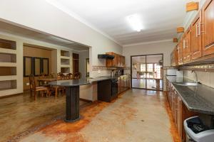 a large kitchen with a table and a dining room at Somethin Special in Mokopane