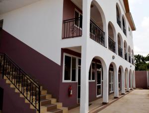 阿克拉的住宿－Kunta Kinte Hotel，带阳台和楼梯的建筑
