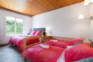 um quarto com duas camas com capas vermelhas em Villa Kenavo - Maison familiale avec vue mer em Île dʼAix