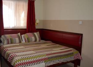 Una cama o camas en una habitación de Kunta Kinte Hotel