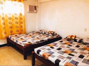 2 Einzelbetten in einem Zimmer mit in der Unterkunft Hacienda Antonio Function Hall and Resort in Pampang