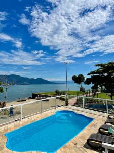 a swimming pool with a view of the water at Pousada Bonns Ventos in Ilhabela