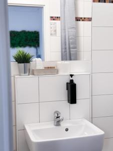 a white bathroom with a sink and a mirror at Hotel Alex Berlin in Berlin