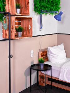 a room with a bed and a table with potted plants at Hotel Alex Berlin in Berlin